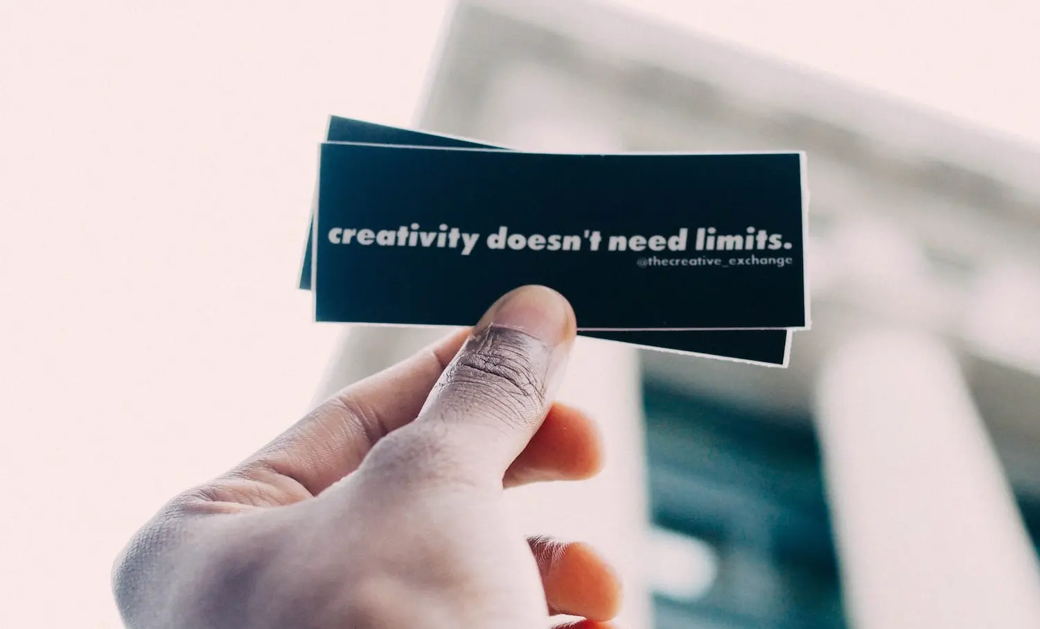 person holding black and white quote-printed card